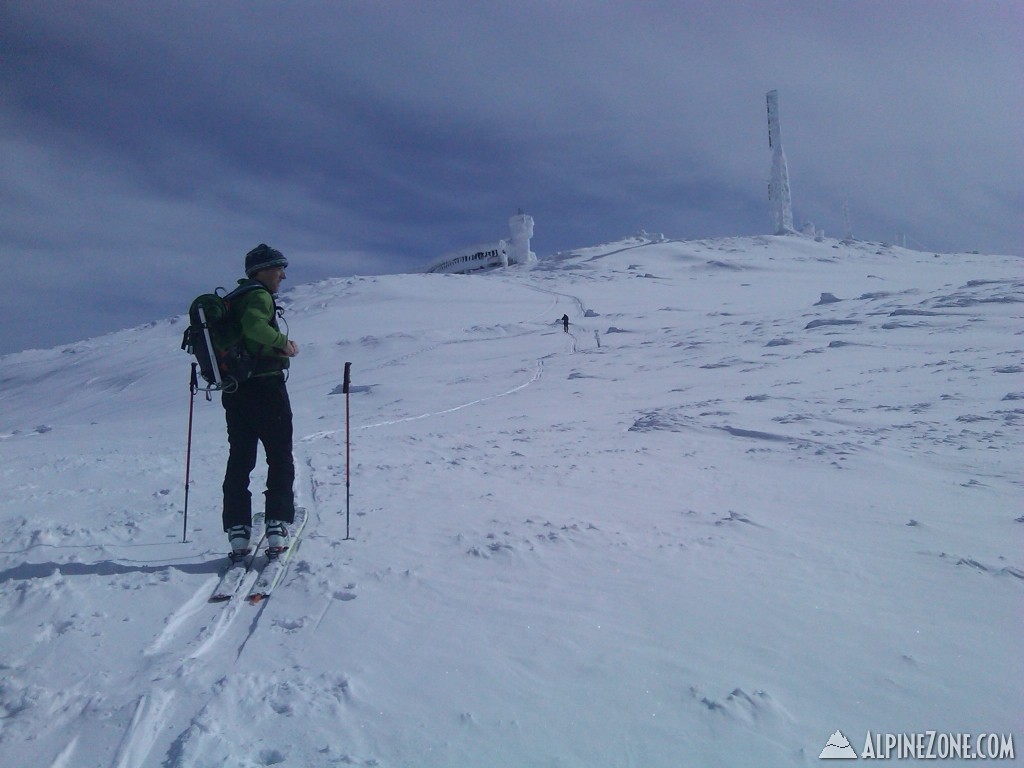 Above the clouds, John surveying the summit snowfields